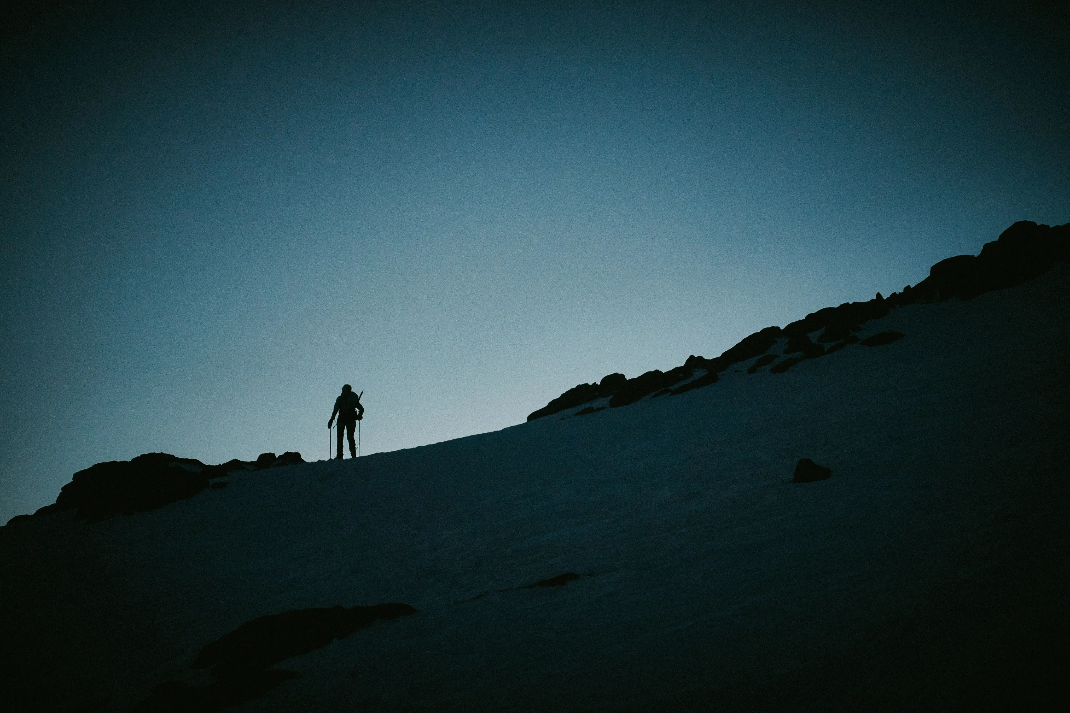 Hiker silhouette on a mountain, night sky